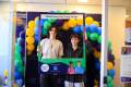 Young people at Positive Transitions Expo, holding corflute New Futures for Young People, surrounded by balloons
